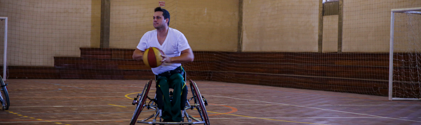 usuario de cadeira de rodas com uma bola de basquete